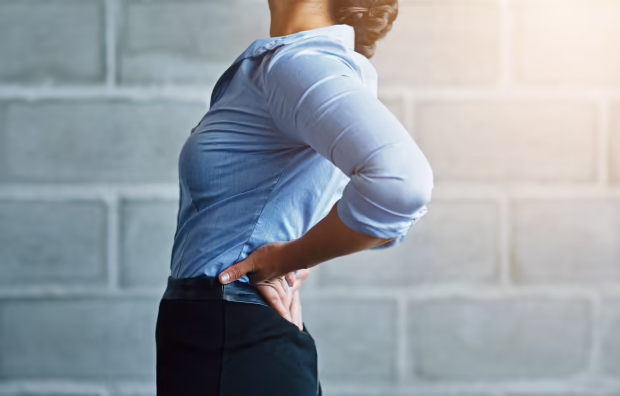 woman experiences lower back pain in office settin 2026 03 25 02 43 17 utc
