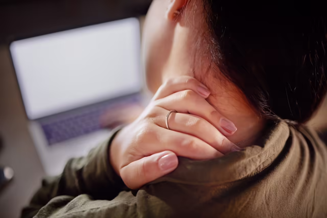woman massaging her neck while using laptop 2026 01 09 09 53 19 utc